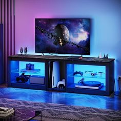 a living room with a large television on top of it's entertainment center next to a purple wall