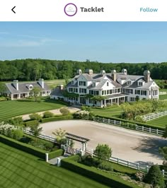 an aerial view of a large white house in the middle of a lush green field