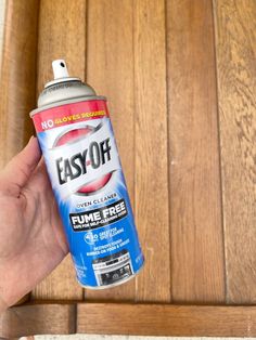 a hand holding a spray can of easy - off