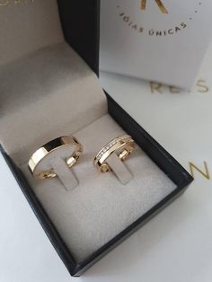 two gold rings sitting in a box on top of a table