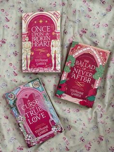 three books laying on top of a bed covered in pink and green covers, one is for children