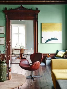 a living room filled with furniture and green walls