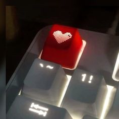 a computer keyboard with a red heart on it's backlit keypads