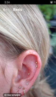 a close up of a person's ear with small piercings on the side