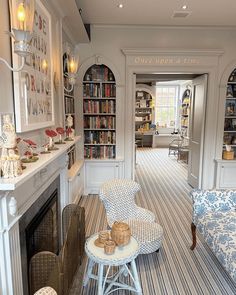 a living room filled with furniture and bookshelves next to a fire place in front of a fireplace