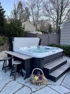 a hot tub sitting on top of a stone patio