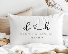 a white pillow with the word d & h printed on it