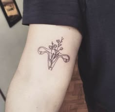 a person with a tattoo on their arm holding a flower in the shape of a cross