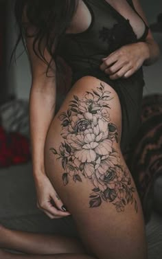 a woman with flowers on her thigh and the words women tattoos written in front of her