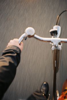 a person riding on the back of a bike down a street next to another person