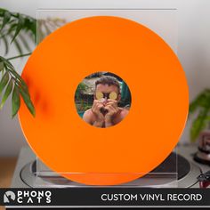 an orange vinyl record with a photo on it