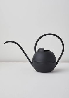 a black teapot sitting on top of a white table