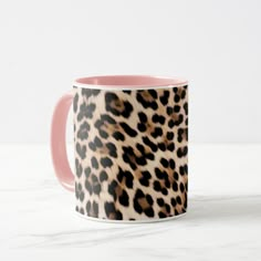 a pink and black leopard print coffee mug on a marble countertop with white background