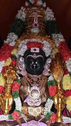 the idol is surrounded by flowers and other decorations