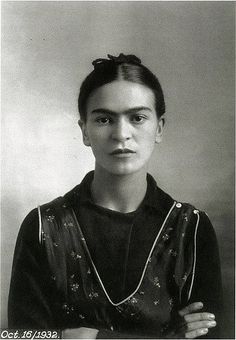 an old black and white photo of a woman with her hands folded in front of her chest