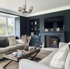 a living room with two couches and a coffee table in front of a fireplace