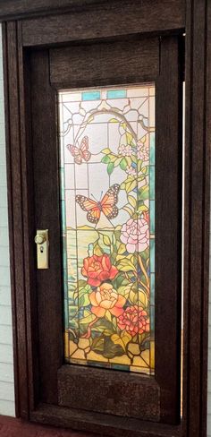 a stained glass door with flowers and butterflies