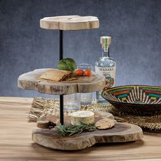 three tiered tray with food and drink on it sitting on top of a wooden table