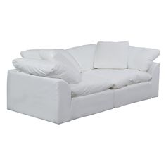 a white couch with pillows on the back and arms, sitting in front of a white background