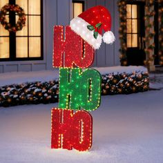 a lighted sign that says oh ho hoo in front of a house with christmas lights