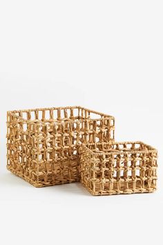 three woven baskets sitting side by side on a white surface, one is empty and the other has no handles