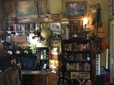 a room filled with lots of books and musical instruments