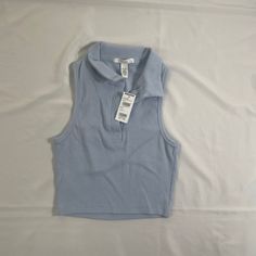 Rsq Women’s Sleeveless Polo Shirt . - Ribbed Construction - Fitted Top - Crop Top - Machine Wash Fitted Sleeveless Casual Top, Casual Fitted Sleeveless Tops, Trendy Cropped Blue Vest, Trendy Blue Vest Top, Blue Cropped Vest For Spring, Trendy Sleeveless Blue Vest, Trendy Blue Sleeveless Vest, Light Blue Stretch Sleeveless Crop Top, Trendy Blue Tank Vest