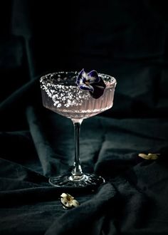 a glass filled with liquid sitting on top of a black cloth