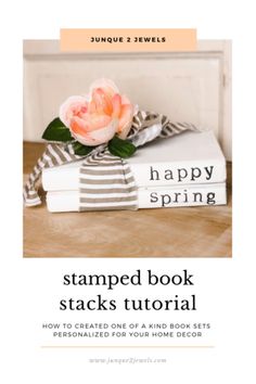 a stack of books sitting on top of a wooden table next to a pink flower