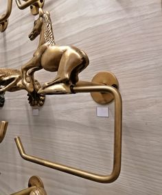 brass horse hooks are on the wall next to each other