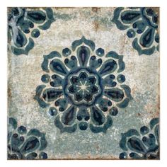 a blue and white tile with an ornate design on the bottom half of it's surface