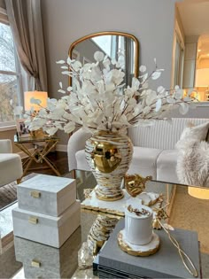 a vase with white flowers sitting on top of a table in front of a mirror