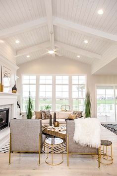 a living room filled with furniture and a fire place in front of a large window