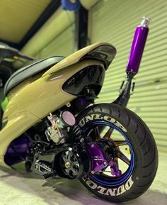 a yellow and purple motorcycle parked in a garage