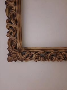 an ornate wooden frame hanging on the wall