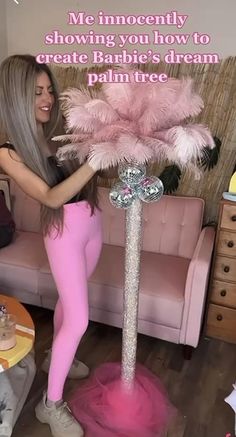 a woman in pink is holding up a pink feather tree with the words, me innocently showing you how to create barbie's dream palm tree