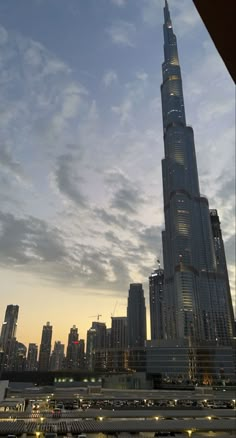 a tall building towering over a city at dusk