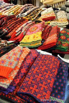 many colorful knitted scarves are on display