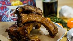 some meat is on a plate with sauces and other food items around the table