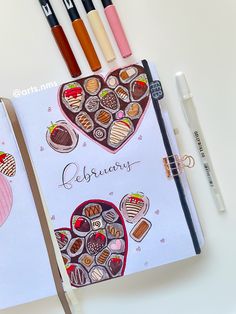 an open notebook with chocolates and hearts on it, next to pens and markers