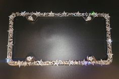 a silver metal frame with stars and jewels on the edges, set against a black background