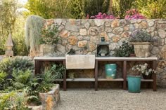 a stone wall with potted plants on it