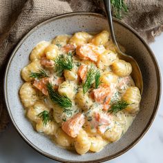 a bowl filled with macaroni and cheese covered in salmon