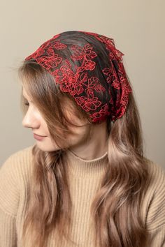 a woman with long hair wearing a red and black bandana over her head,