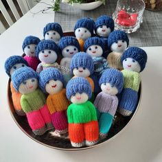 a group of knitted dolls sitting on top of a plate