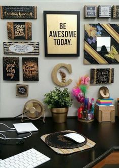 a desk with a keyboard, mouse and some pictures on the wall above it that says be awesome today