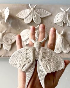 a hand holding a paper sculpture of a butterfly