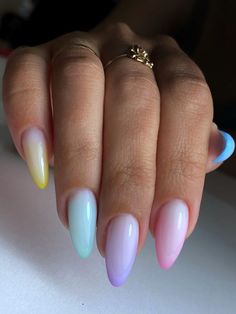 a woman's hand with multicolored nails and ring on her finger,