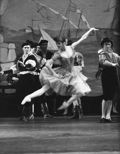 the ballerina is dancing in front of other dancers