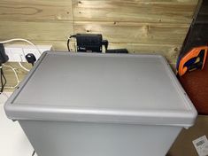 a small refrigerator sitting on top of a counter next to a cordless phone charger